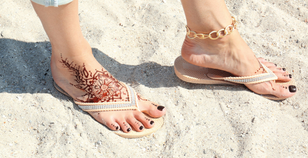 tijdelijke tatoeage op de voeten van een vrouw op het strand
